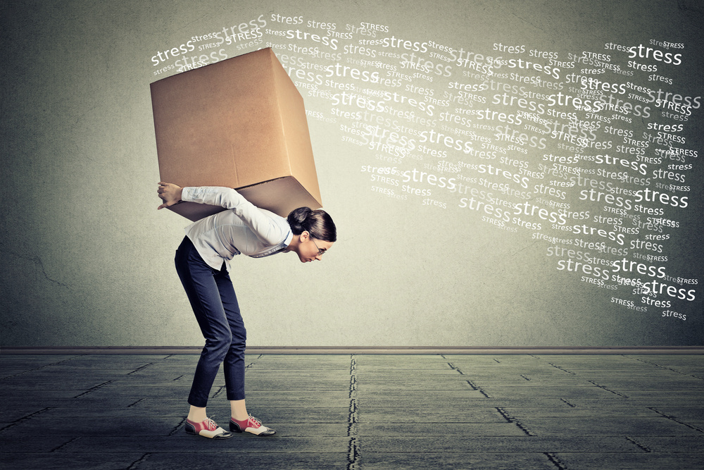 Stressed woman carrying on her back shoulders large box Stressed woman carrying on her back shoulders large box